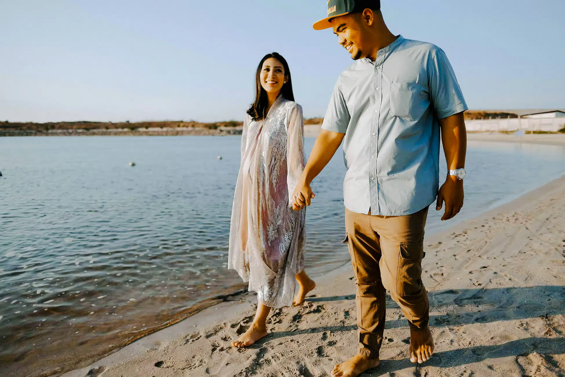 Couple walking along a beach during a professional photoshoot in Jakarta.