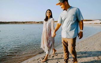 Couple walking along a beach during a professional photoshoot in Jakarta.