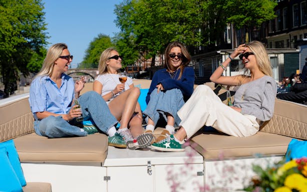 Friends enjoying a canal cruise in Utrecht on an open boat.