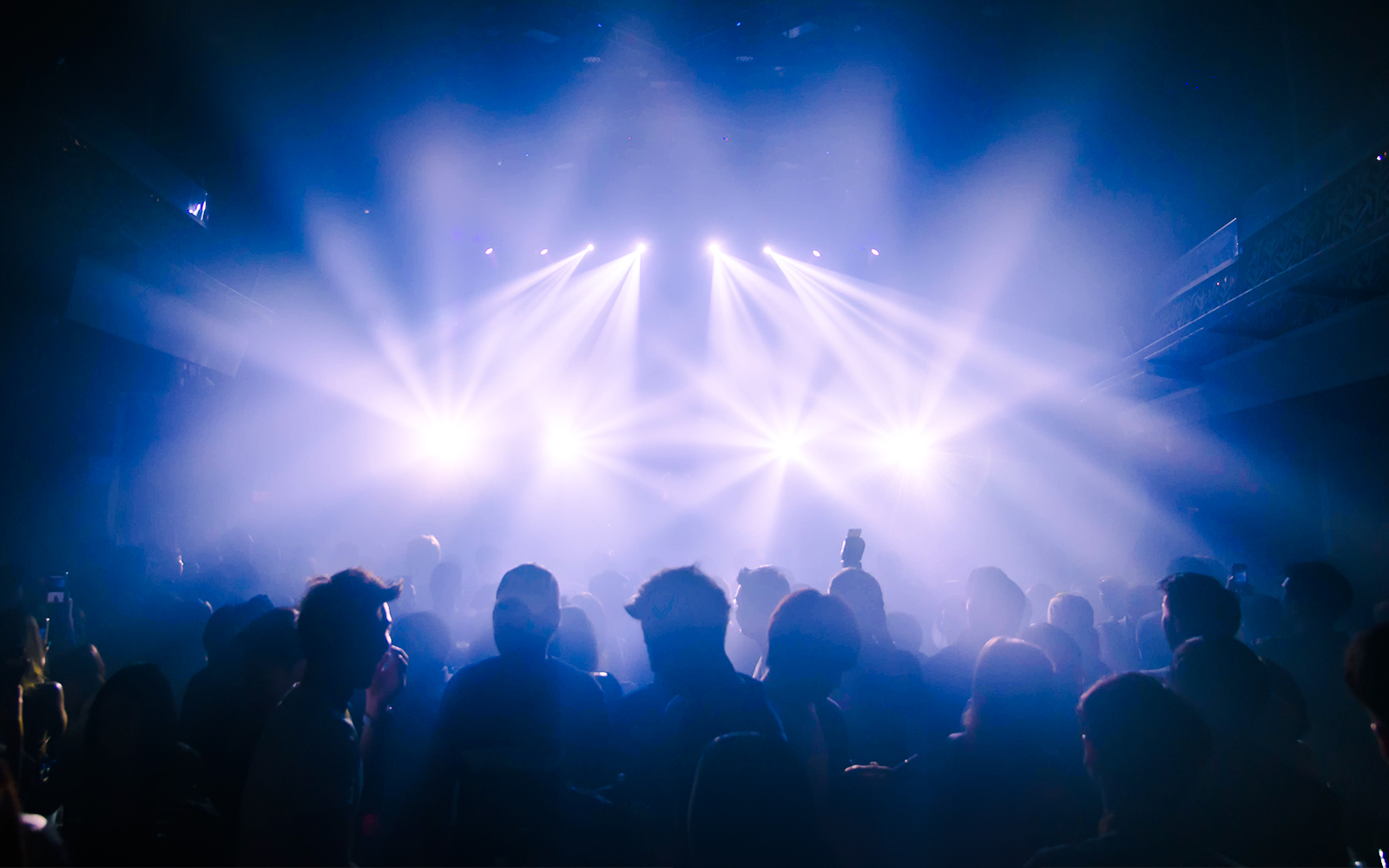 People dancing under bright lights at a nightclub in Ibiza.