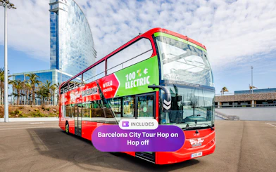 Barcelona hop-on hop-off bus near W Hotel with palm trees in the background.