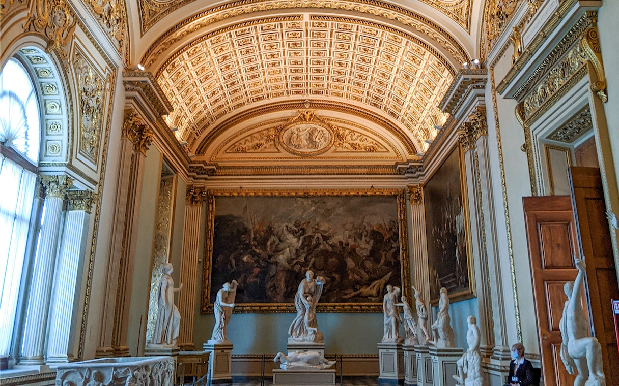 Uffizi Gallery interior with classical sculptures and ornate ceiling, Florence.