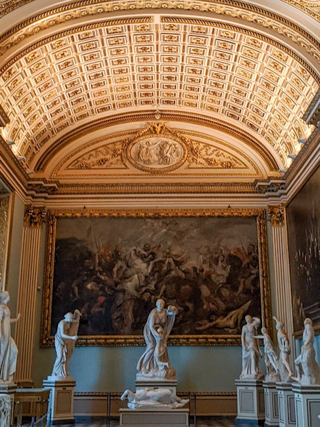 Uffizi Gallery interior with classical sculptures and ornate ceiling, Florence.