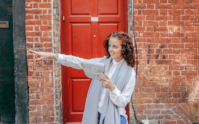Tourist with map pointing during Westminster Walking Tour near red door.