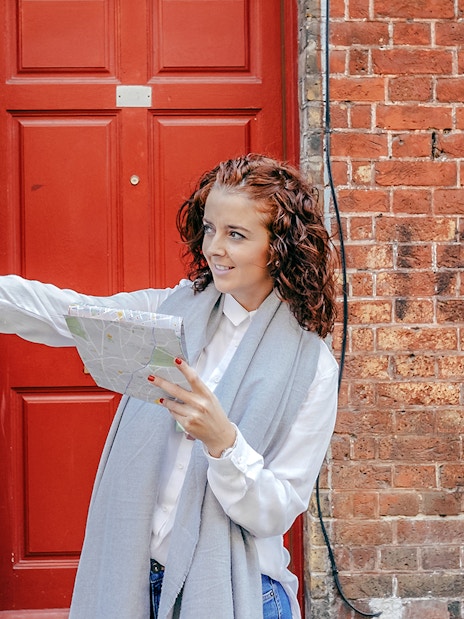 Tourist with map pointing during Westminster Walking Tour near red door.