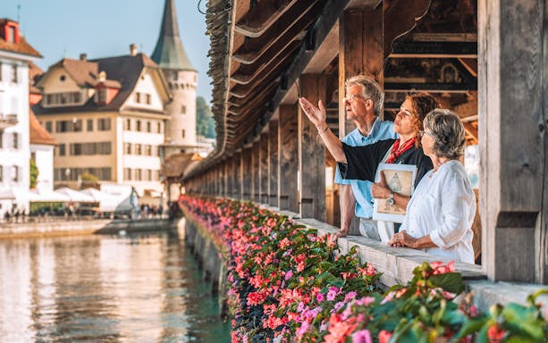 Guide explaining the history of Chapel Bridge to small group tour, Lucerne