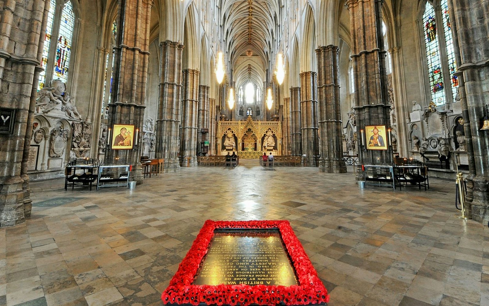 Tomb of the Unknown Soldier surrounded by poppies inside Westminster Abbey, London.