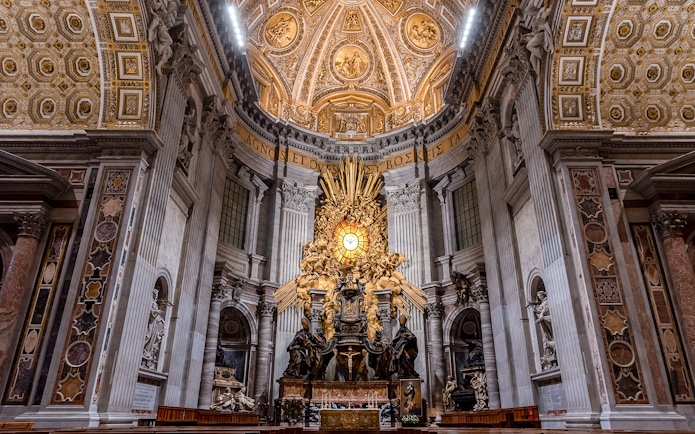 Altar of St. Peter's Basilica with ornate ceiling and sculptures, Vatican City.