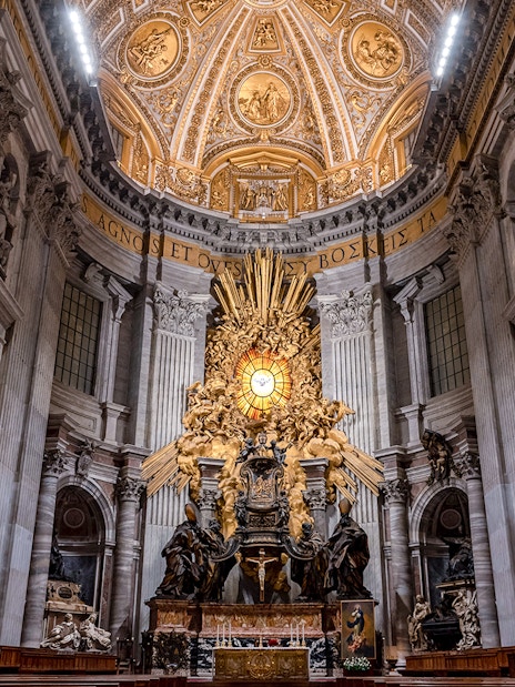 Altar of St. Peter's Basilica with ornate ceiling and sculptures, Vatican City.