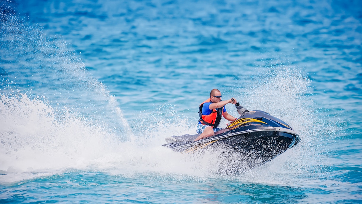 Young man riding a jet ski on the ocean in Dubai.