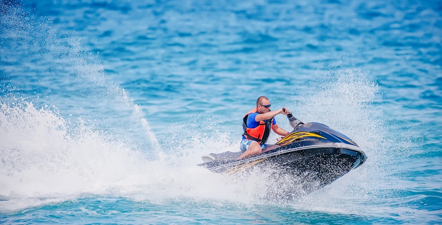 Young man riding a jet ski on the ocean in Dubai.