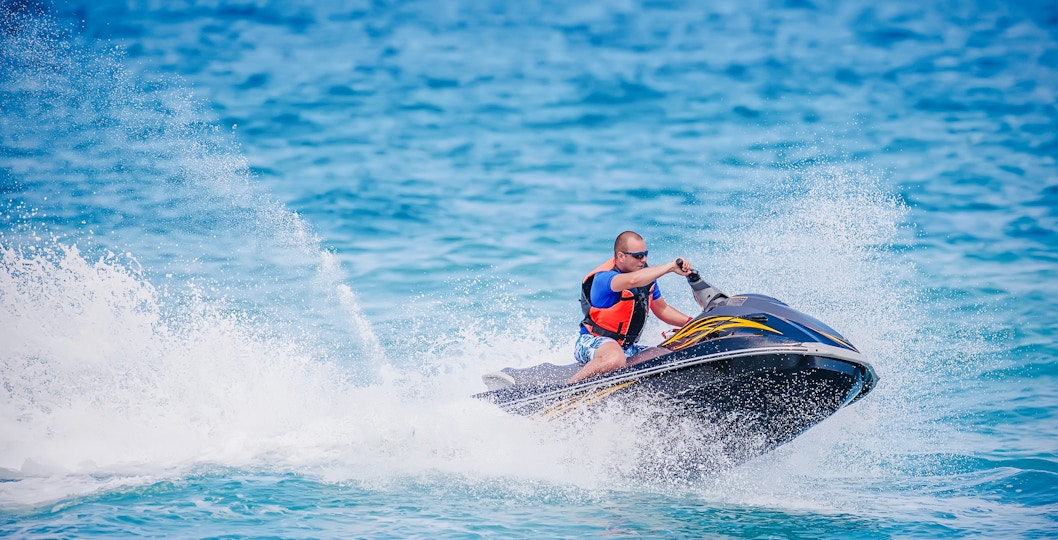 Young man riding a jet ski on the ocean in Dubai.