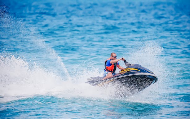 Young man riding a jet ski on the ocean in Dubai.