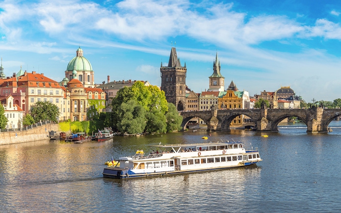 Prague Castle tour boat on Vltava River near Charles Bridge.