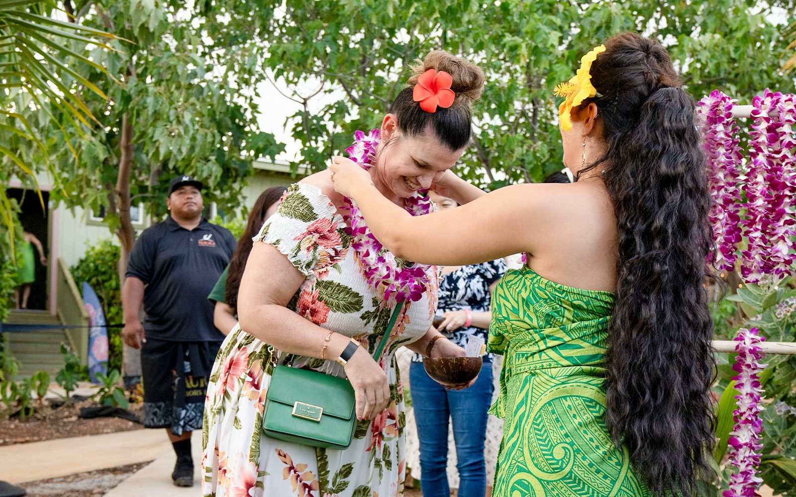 Staff at Mauka warriors Luau greeting guests with a traditional Lei flower garland