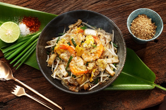 Pad Thai with shrimp, bean sprouts, and lime on a banana leaf in Thailand.