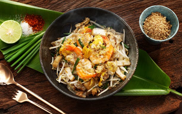 Pad Thai with shrimp, bean sprouts, and lime on a banana leaf in Thailand.