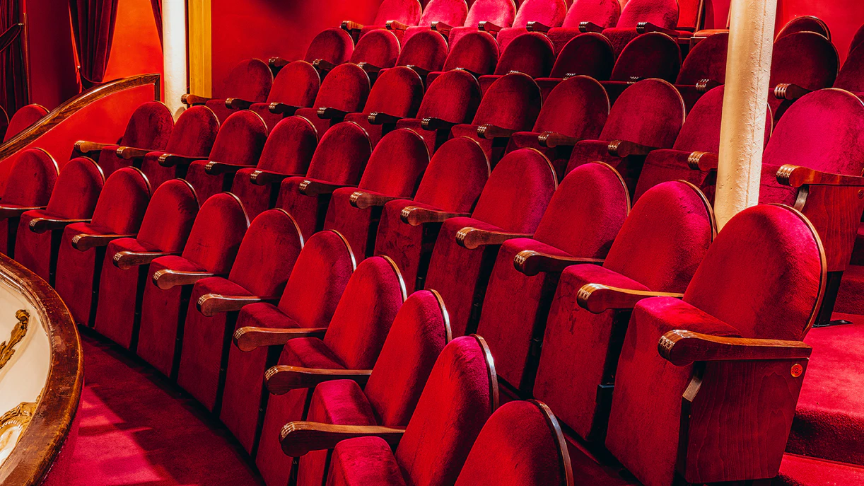 Red velvet seats in the Lyceum Theatre, London, arranged in rows.