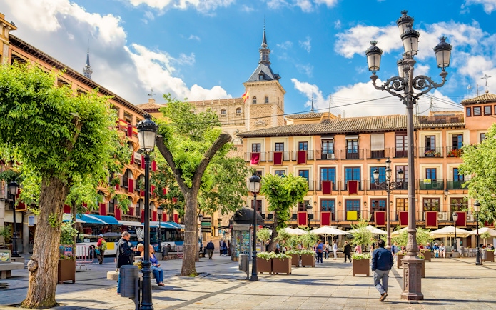 Toledo Stadtzentrum with historic buildings and people in a lively plaza.
