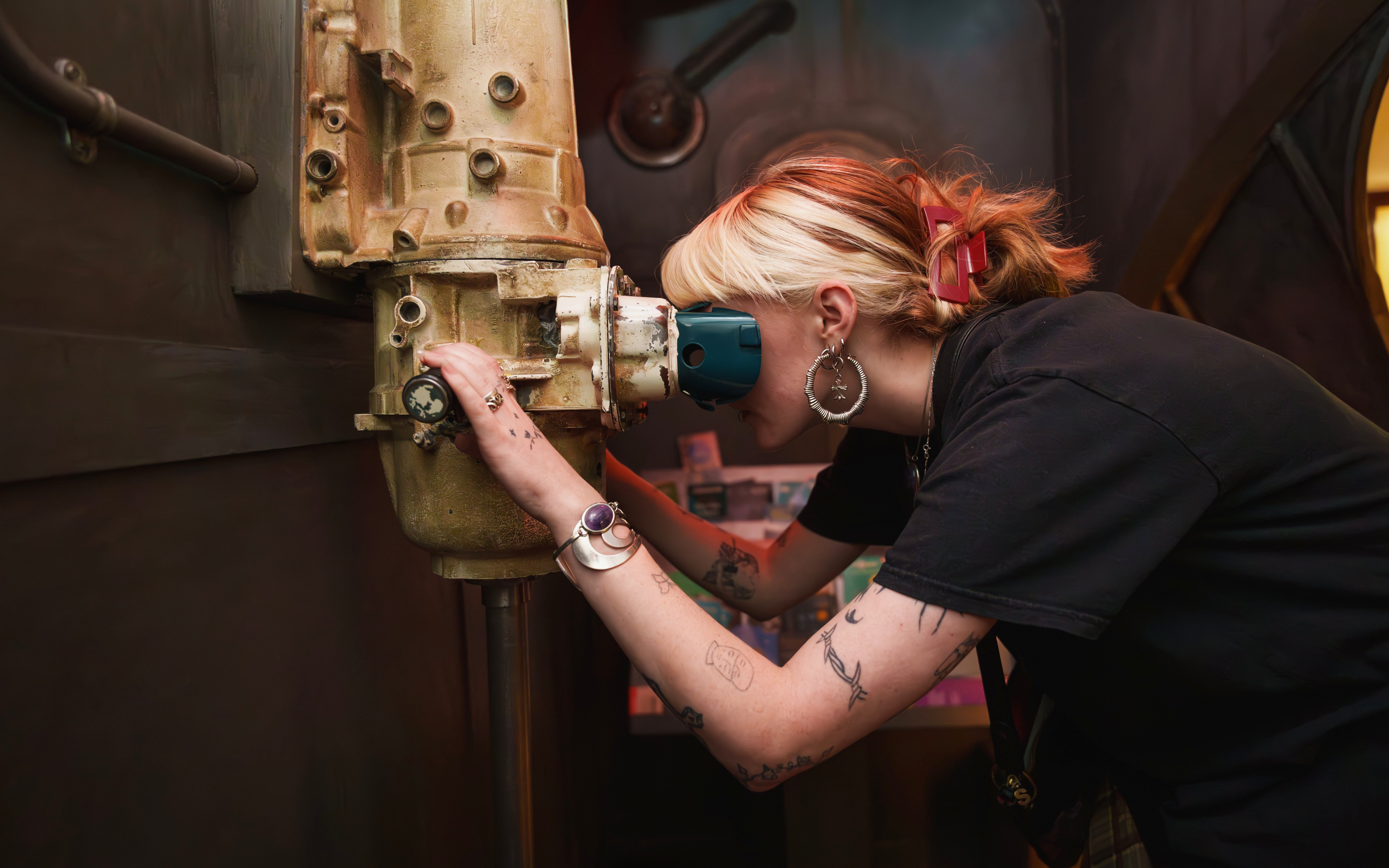 Person looking through a periscope at the National Wax Museum exhibit.