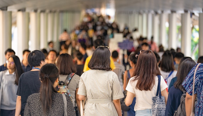 Crowd walking through Times Square, New York City, surrounded by a dull underground environment.