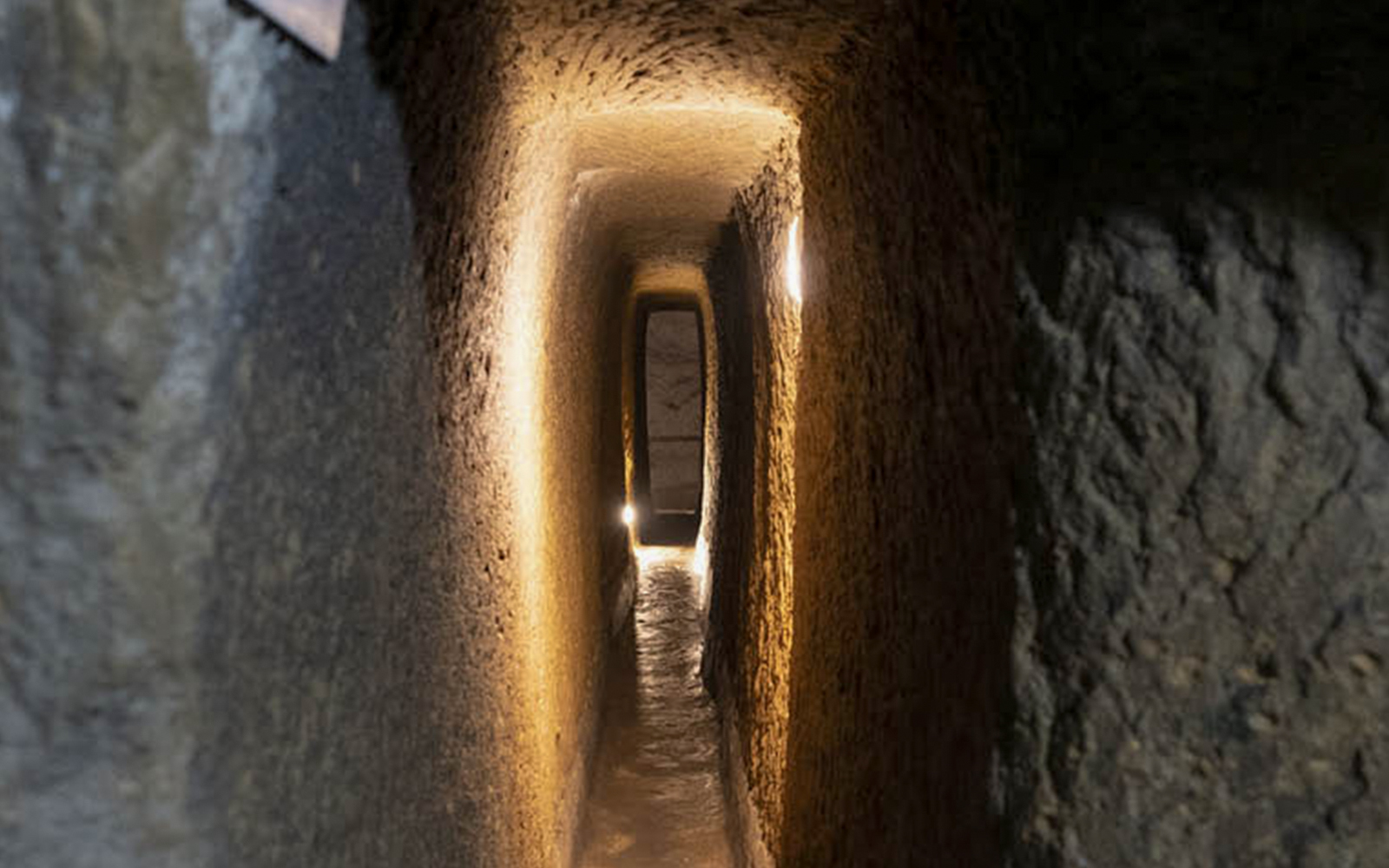 Naples Underground tunnel with illuminated stone walls.