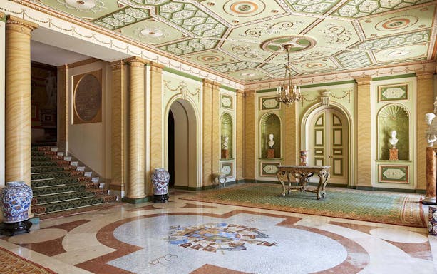 Liria Palace interior with ornate ceiling, marble floor, and classical busts.