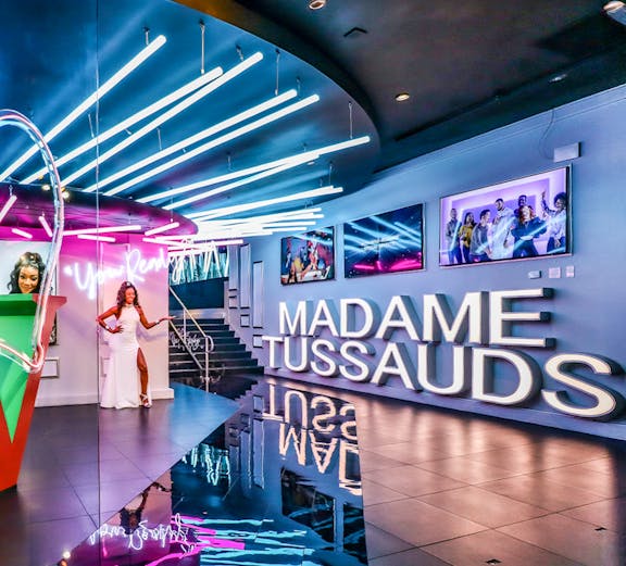 Madame Tussauds Las Vegas entrance with neon lights and wax figure display.