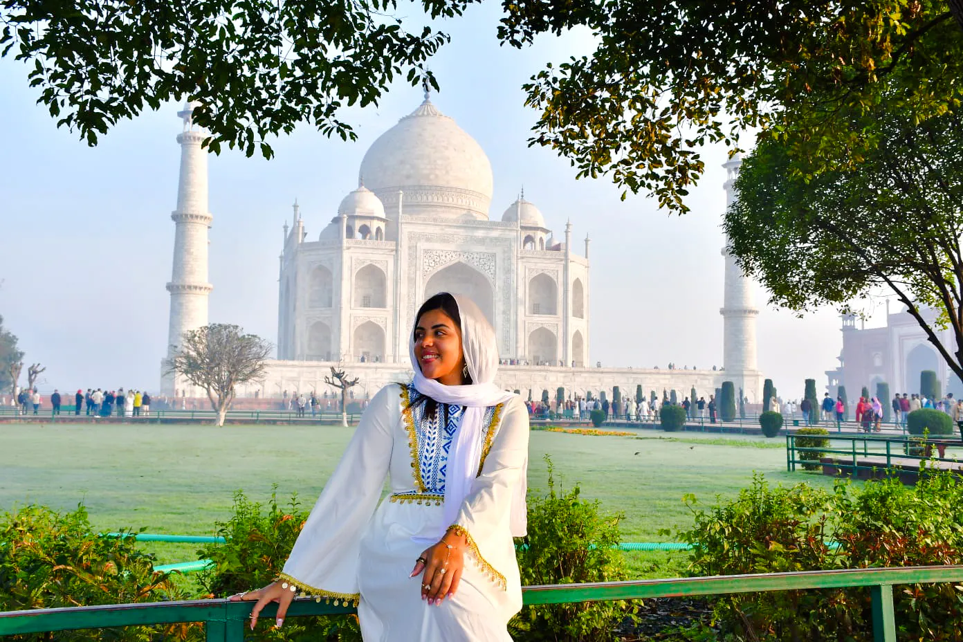 Sunrise view of the Taj Mahal with a visitor in traditional attire, Agra tour.