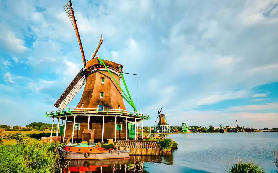 Windmill by the water in Volendam, Netherlands, with a boat in the foreground.