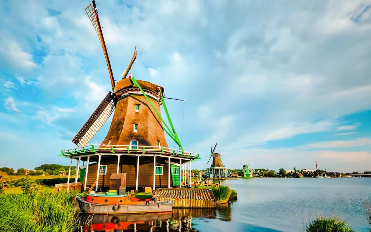 Windmill by the water in Volendam, Netherlands, with a boat in the foreground.