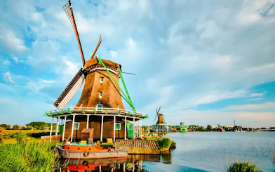 Windmill by the water in Volendam, Netherlands, with a boat in the foreground.