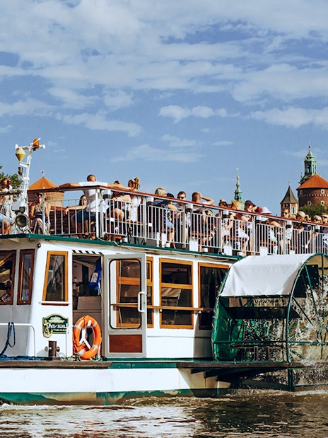 Cruise boat on the Vistula River with Wawel Castle in the background, Krakow.