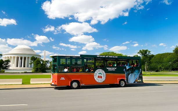 Double-decker bus on Washington DC hop-on hop-off tour passing the US Capitol building.