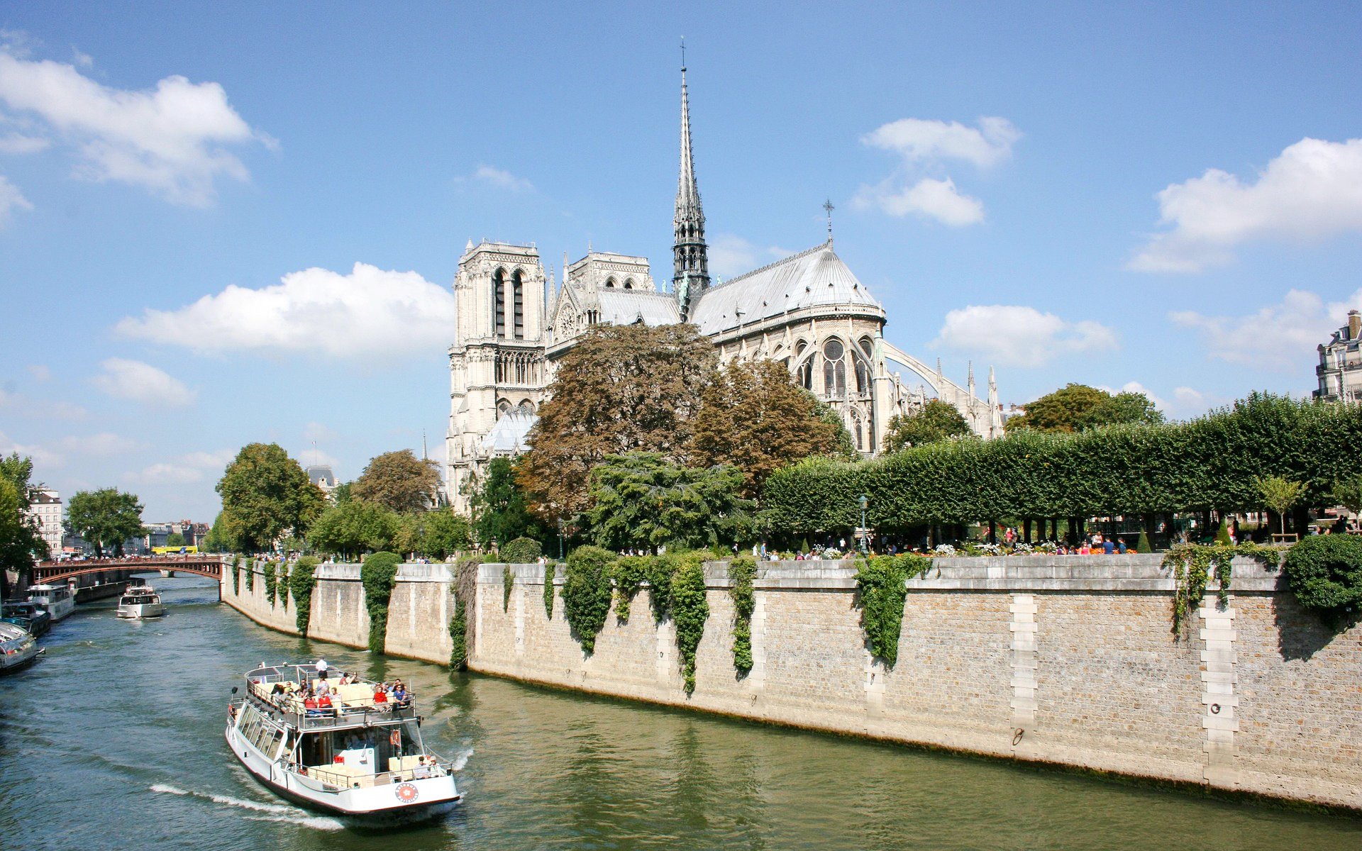Seine River cruise boat passing Notre-Dame Cathedral in Paris, France.