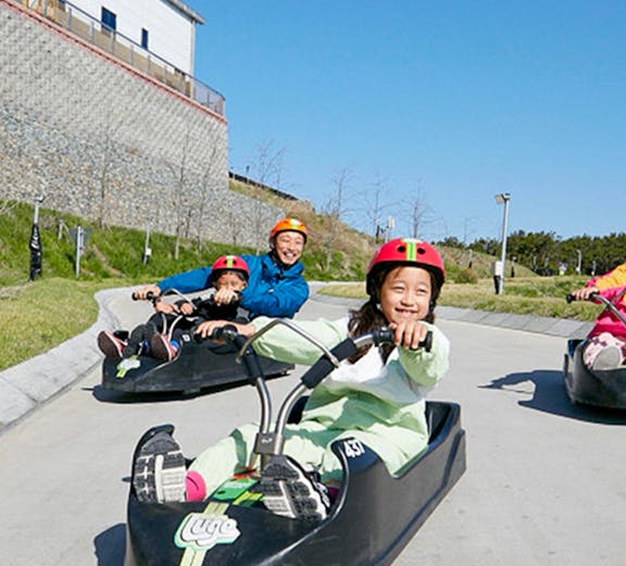 Children enjoying a luge ride at Skyline Luge Busan, South Korea.