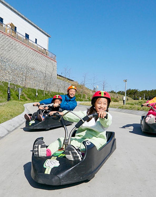 Children enjoying a luge ride at Skyline Luge Busan, South Korea.