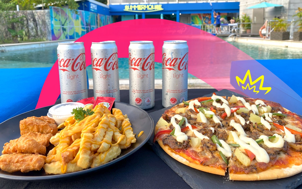 Pizza and fries with chicken by a pool, part of Food Discovery Pass experience.