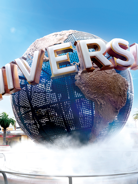 Universal Studios Japan globe with palm trees and clear sky.