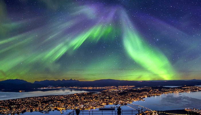 Group of tourists chasing the Northern Lights over Tromso, Norway