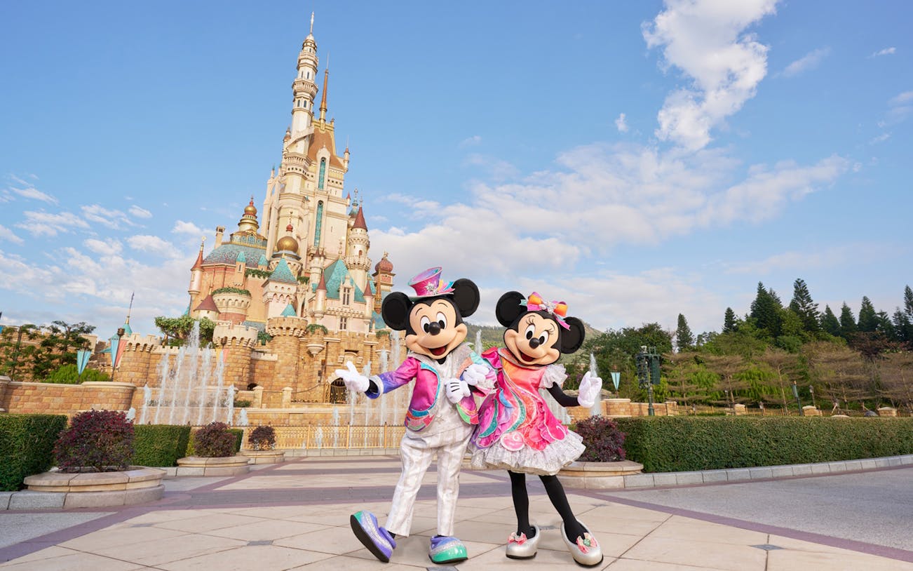 Mickey and Minnie Mouse in front of Sleeping Beauty Castle at Disneyland Hong Kong.