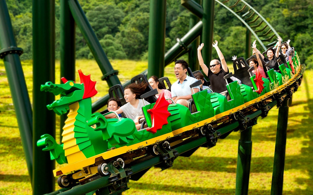 Family riding the Dragon roller coaster at Legoland Theme Park, Malaysia.