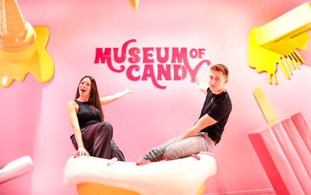 Visitors on cupcake prop at Museum of Candy, Dubai.
