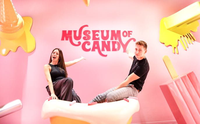 Visitors on cupcake prop at Museum of Candy, Dubai.