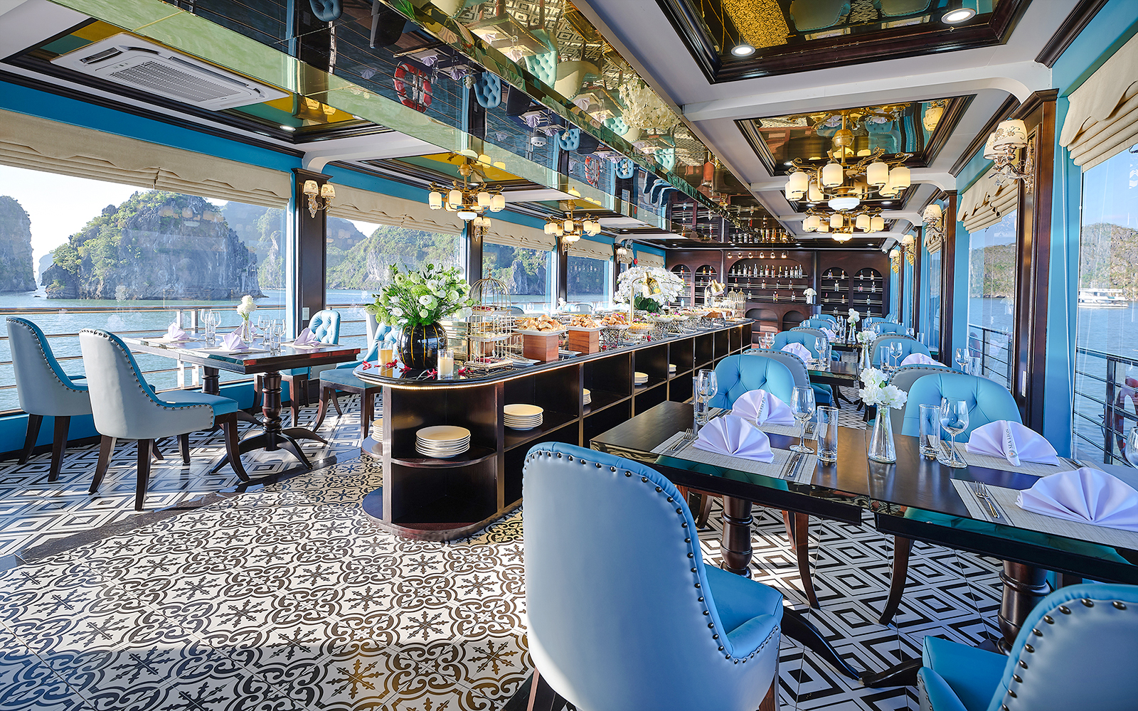 Buffet spread on cruise ship with Ha Long Bay view through dining area windows.