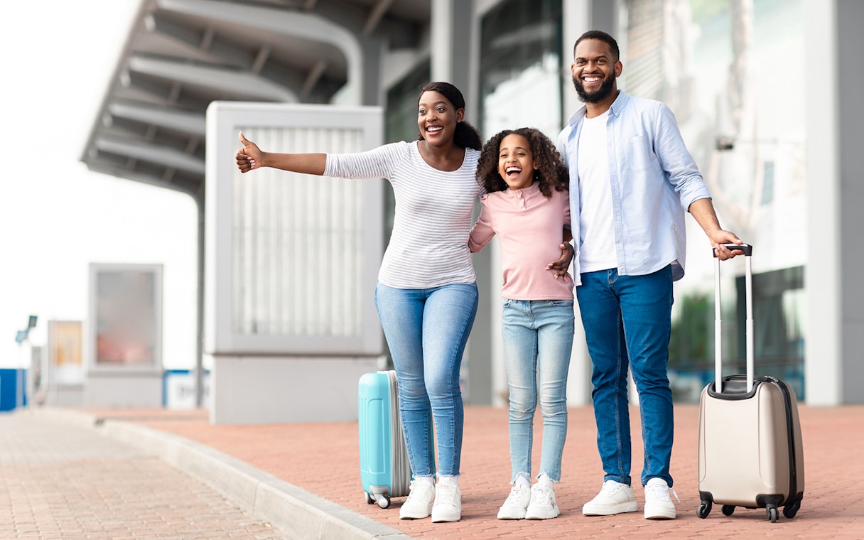 Family with luggage waiting for Paris-Orly Airport private transfer.