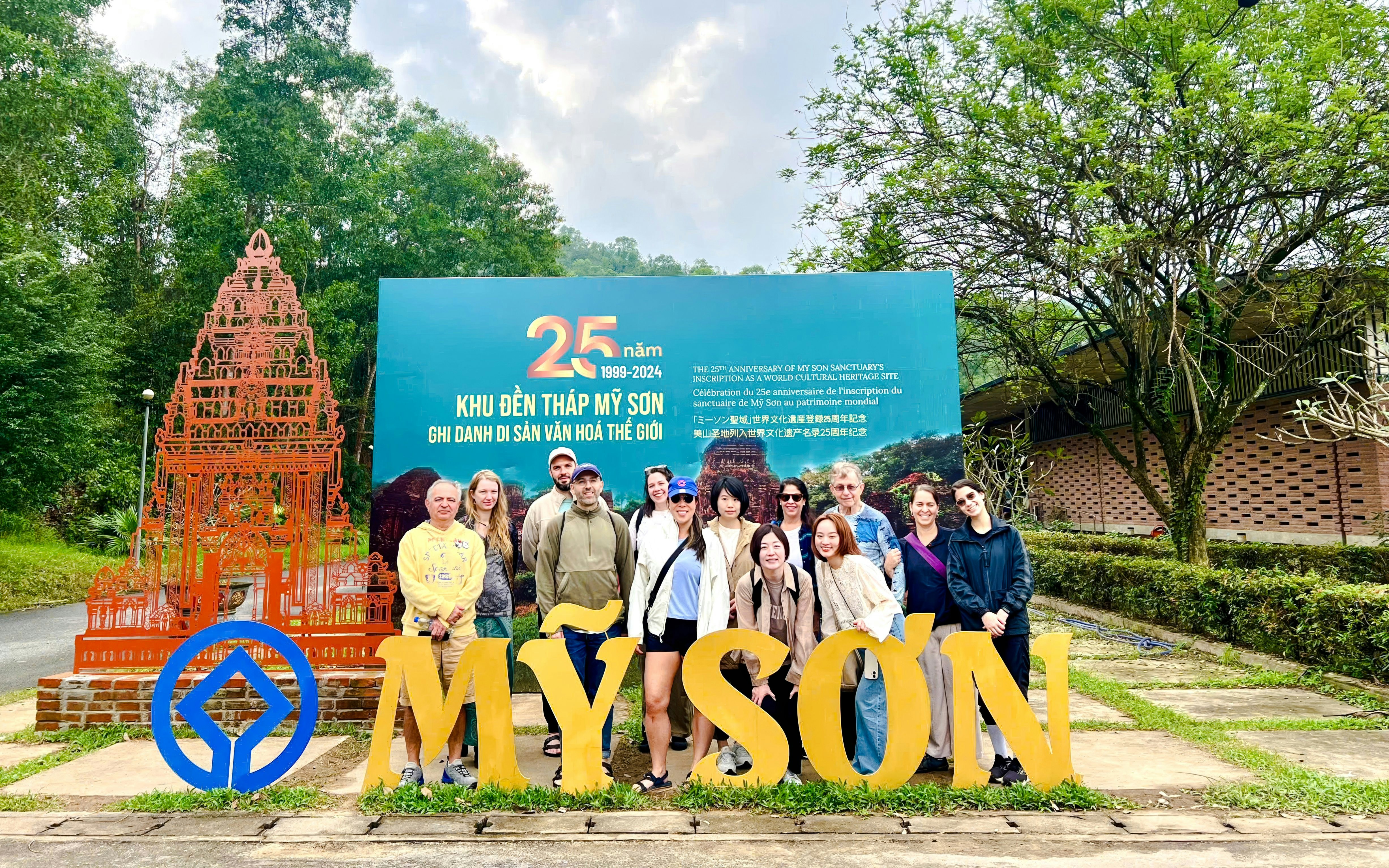 Tourists gathered at the entrance sign of Mỹ Sơn Sanctuary, Vietnam.