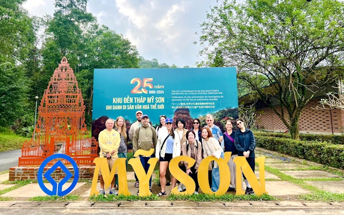 Tourists gathered at the entrance sign of Mỹ Sơn Sanctuary, Vietnam.