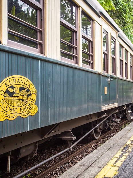 Kuranda Scenic Railway train on a lush forest track in Queensland, Australia.