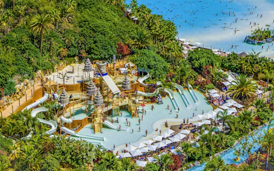 Aerial view of Siam Park's water slides and pools surrounded by lush greenery in Tenerife.